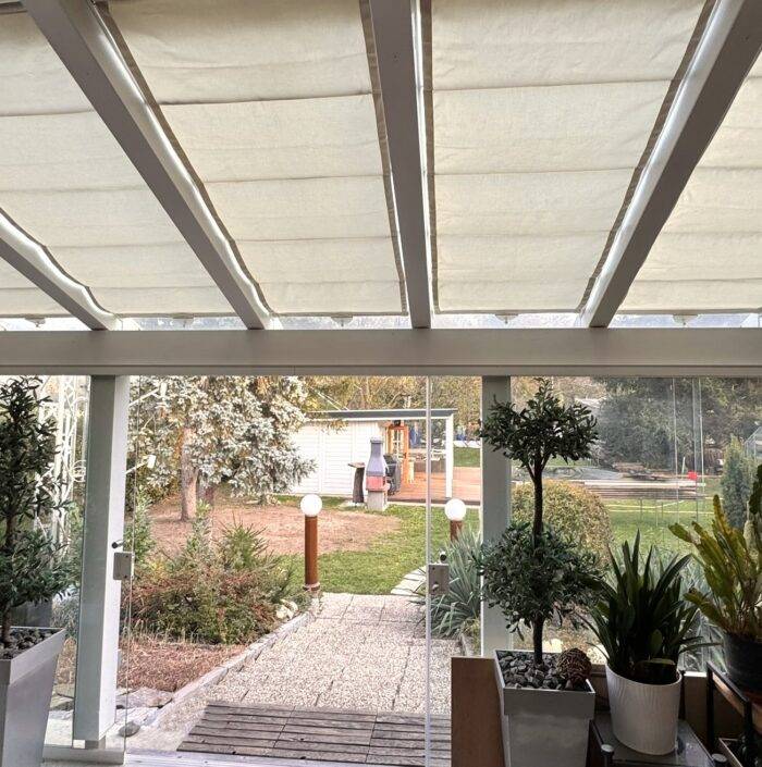 „Schienensegel auf Laufschienen, flexibel verschiebbar zur variablen Beschattung einer Pergola.“